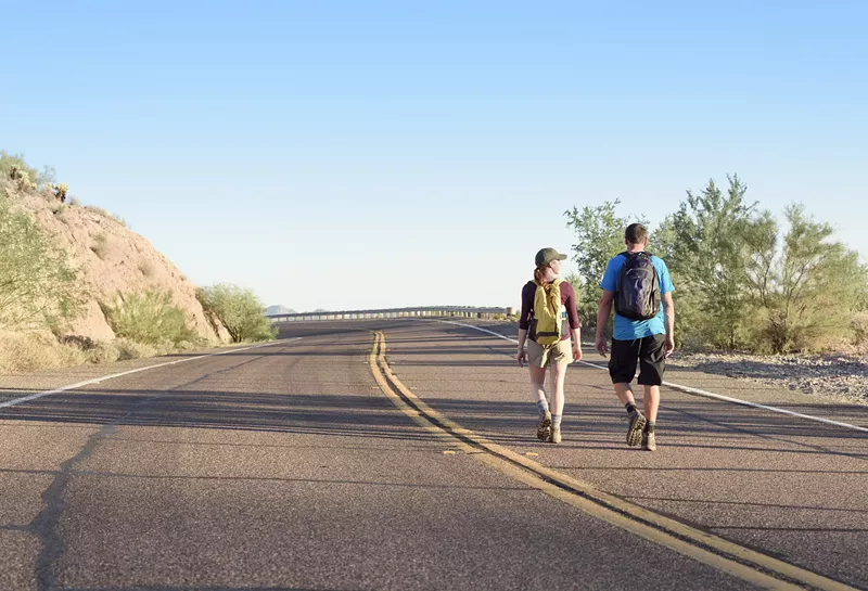 Image: two people walking on an arizona road