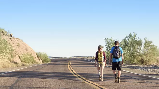 two people walking on an arizona road