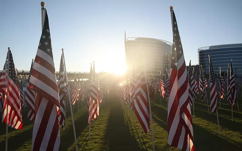 Image: The sunrise peeks through American flags at the Tempe Healing Field at Tempe Beach Park on Sept. 11.