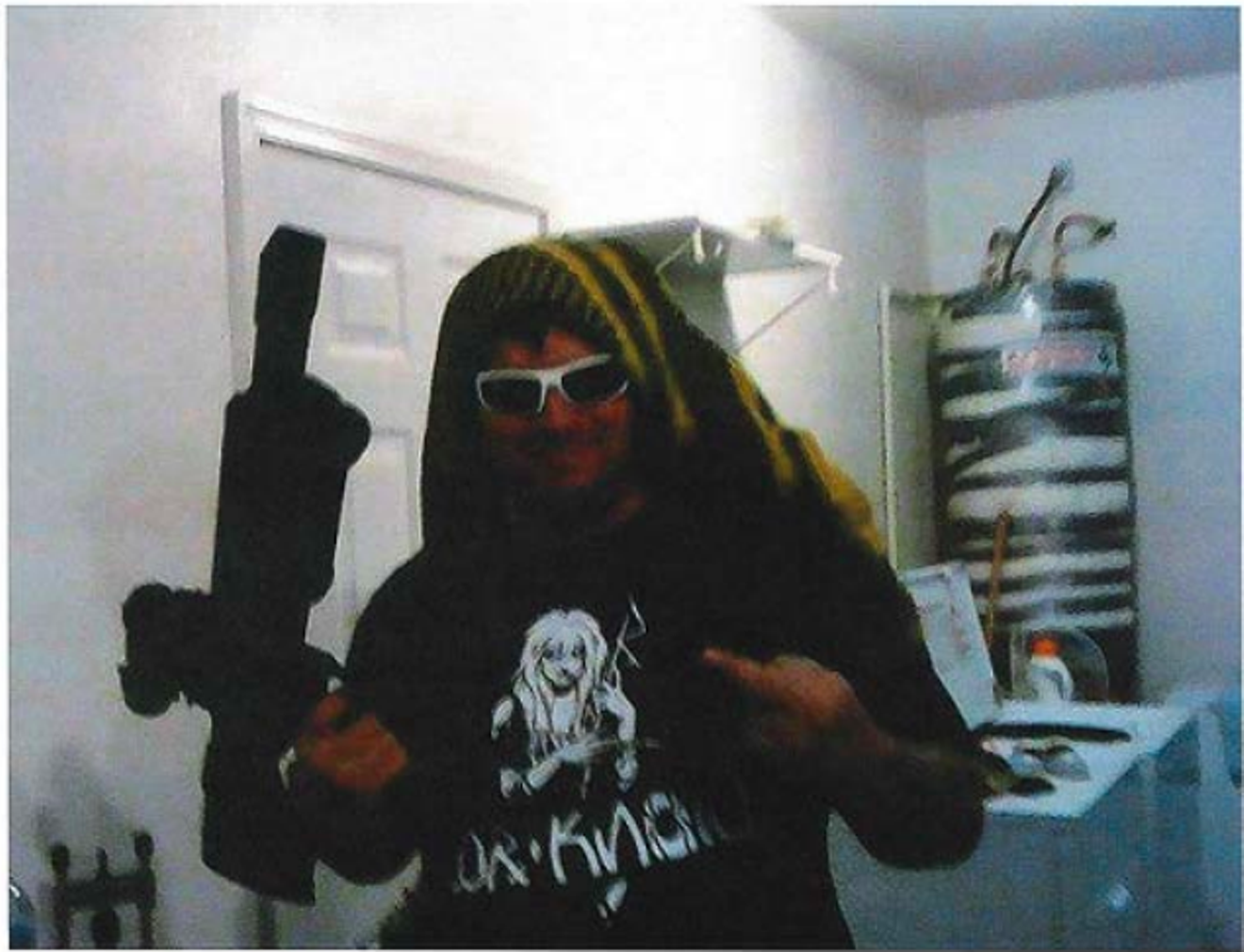 Wells holds a long gun in a photo posted on Facebook.
