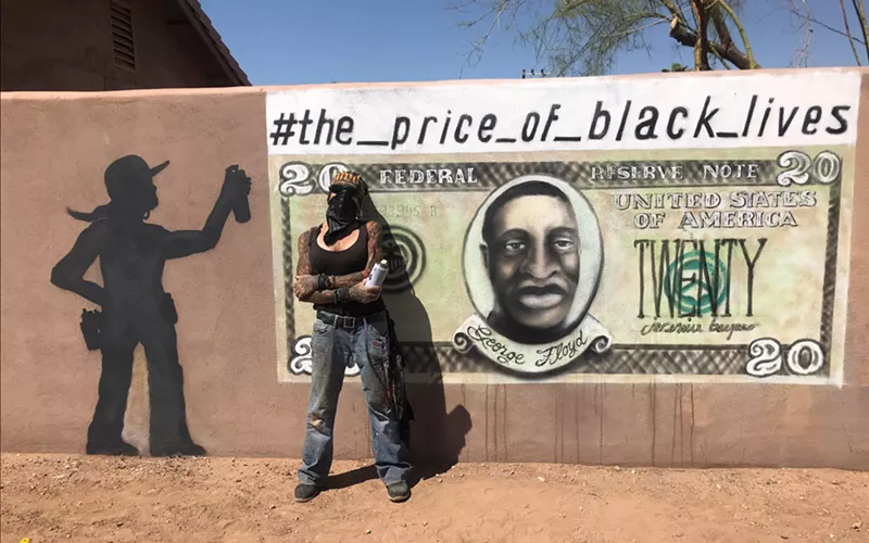 Image: Artist bacpac stands with the restored version of her The Price of Black Lives mural.