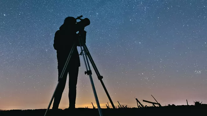 A person looking through a telescope.