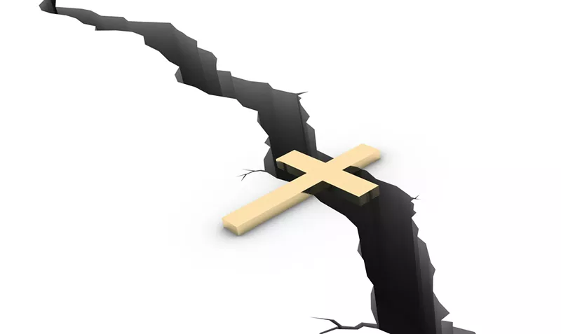 Image: a cross spans a crack in the ground