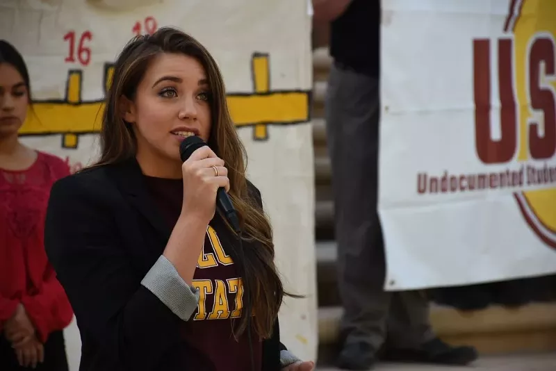 Image: a woman speaks into a microphone