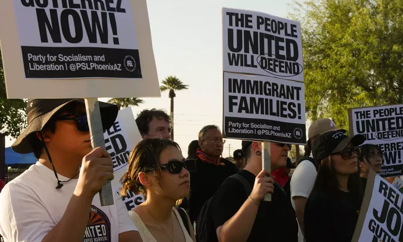 Image: protesters hold signs