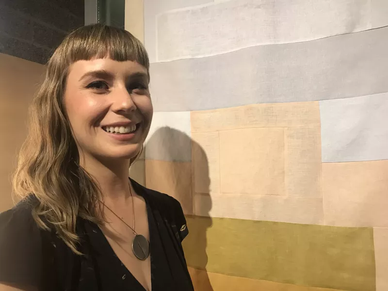 Image: Janel Garza with one of her artworks for a solo exhibition in April 2018.