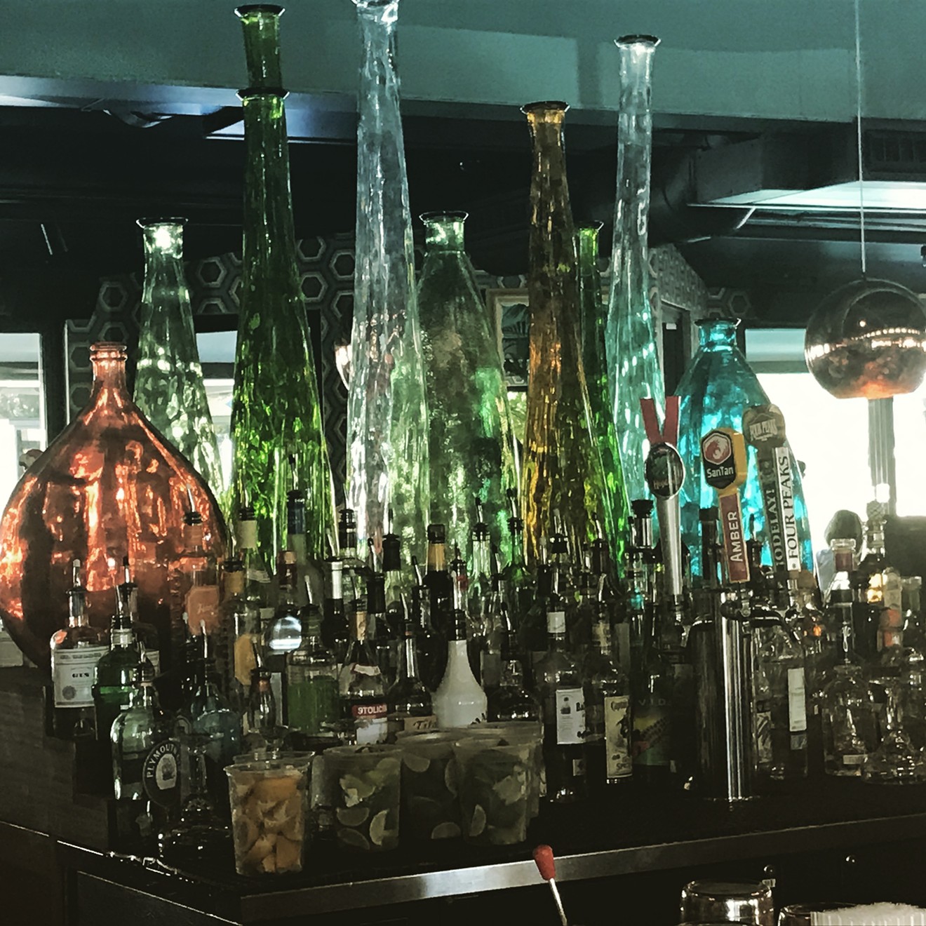 Clear and colorful bottles accessorize the middle of the bar which leads to the fun and festive atmosphere during happy hour.