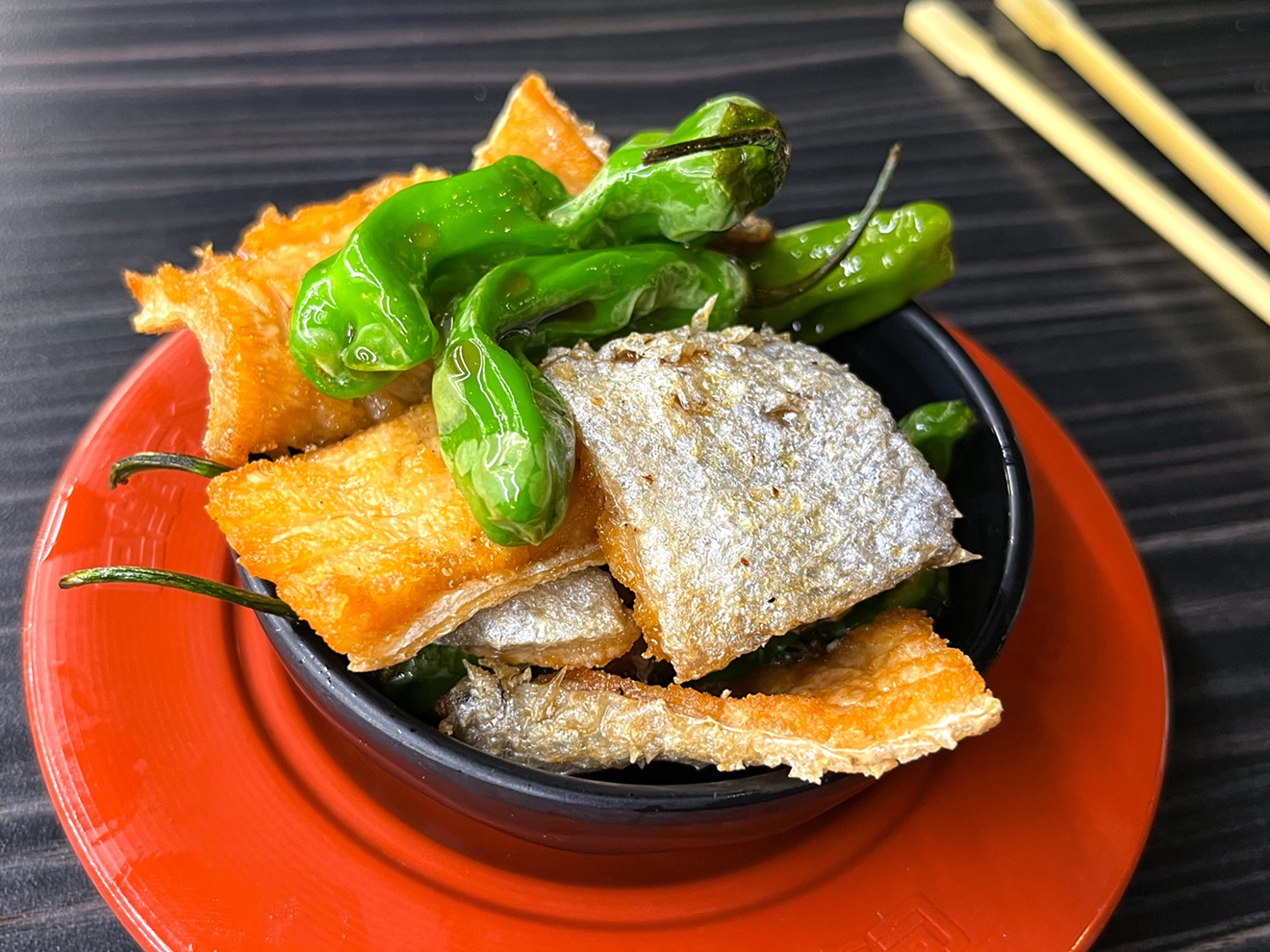 Fried salmon skin with blistered shishito peppers is a genuinely good dish.