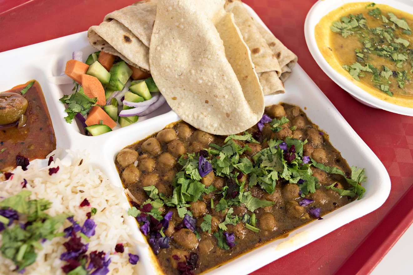 Thali, a combo plate that includes your choice of curry, along with sides of lentil soup, rice, salad, and flatbreads.