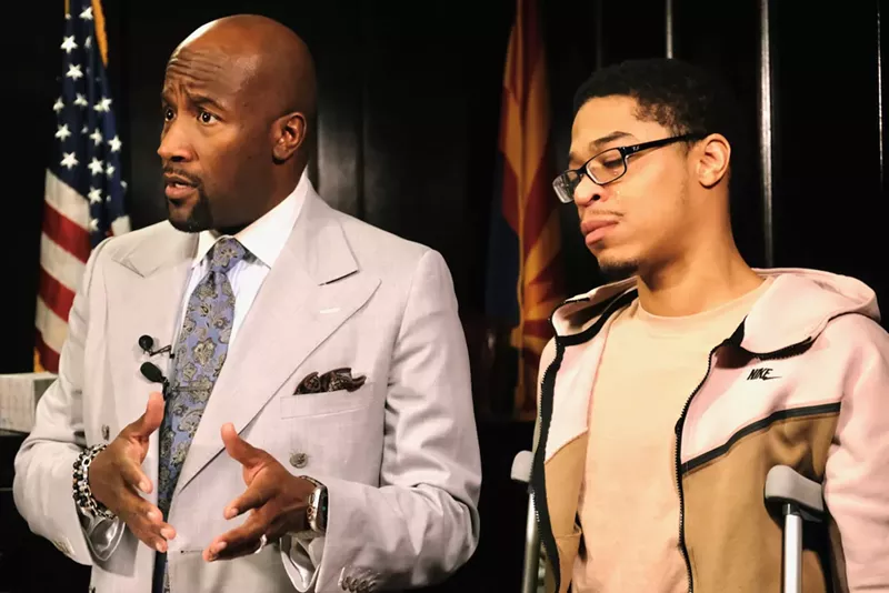 Image: Marshun Neeley (right) tears up as attorney Quacy Smith discusses the police dog attack that seriously injured Neeley. They appeared at a press conference on February 17.