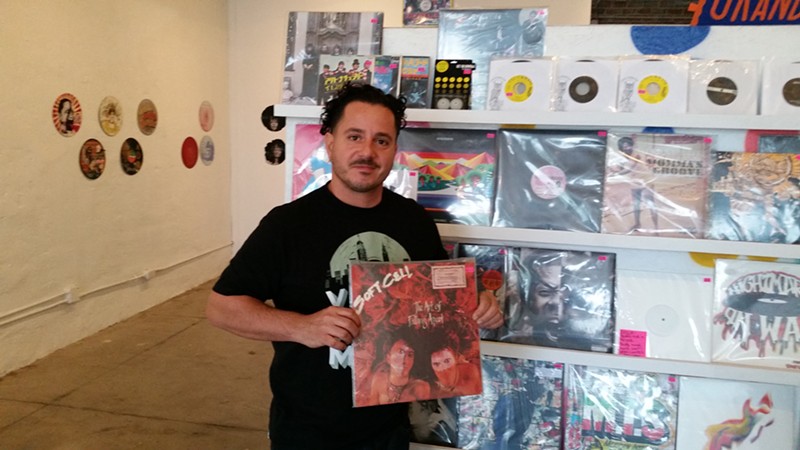 Konstadinos "Cocoe" Tsimahidis holds up a killer Soft Cell record at his Grand Avenue Records store. It's probably already sold.