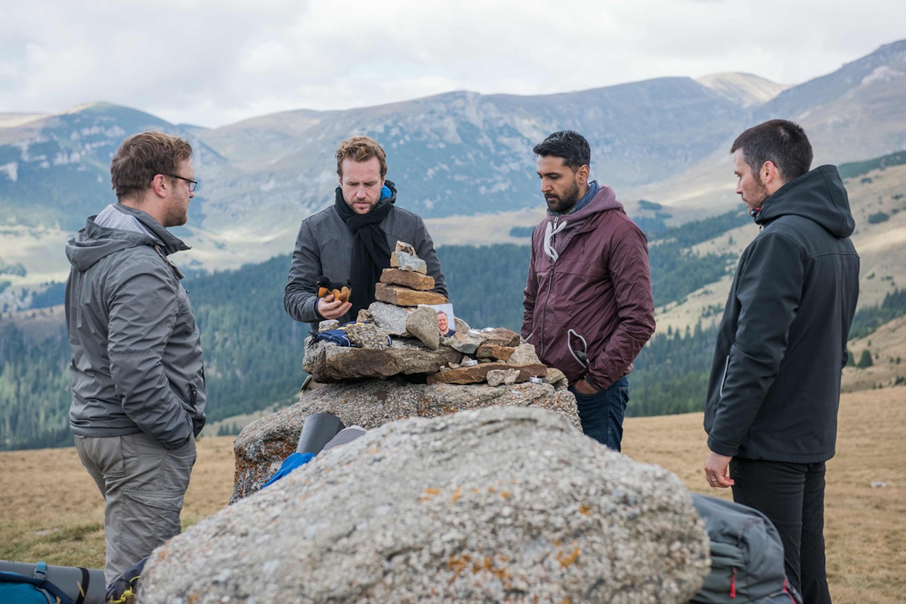 Four British lads played by (from left) Sam Troughton, Rafe Spall, Arsher Ali, and Robert James-Collier hike through the deserted woods of northern Sweden before bashing open the door of a decrepit cabin to spend the night there in The Ritual.