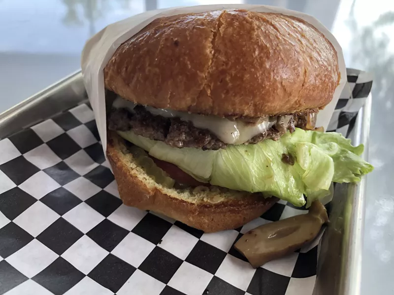 Image: Single patty burger with five or so toppings.