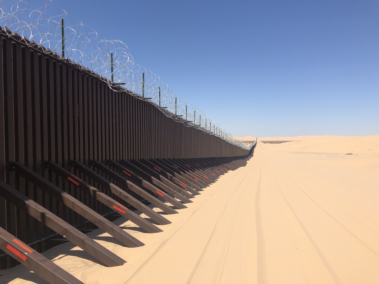The border wall separating Yuma and Mexico along the Imperial Sand Dunes.