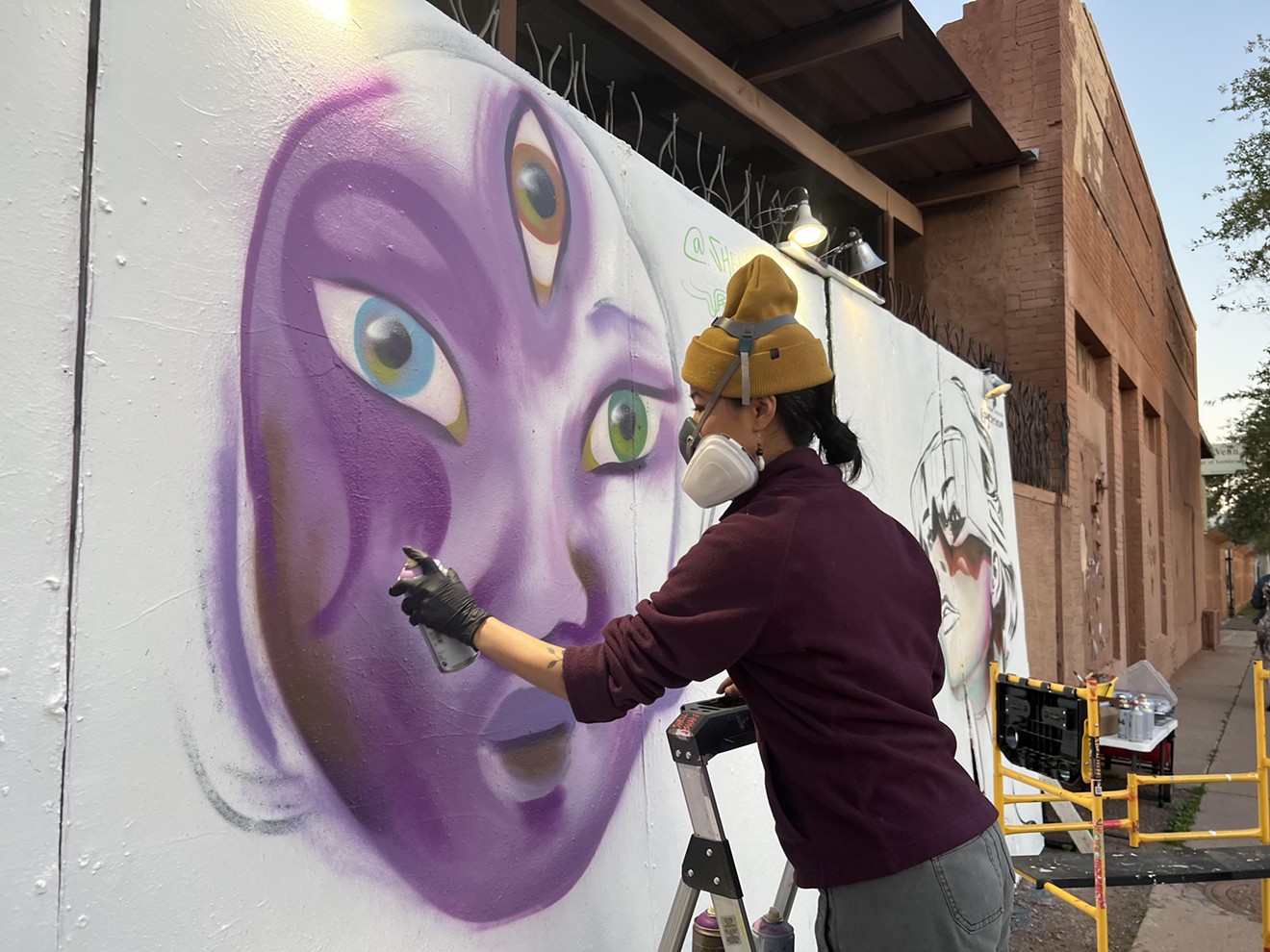 Shela Yu paints outside Snood City Neon.