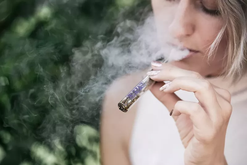 Image: someone smoking weed out of a pipe