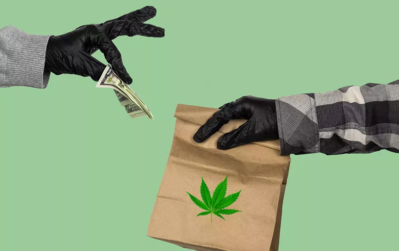Image: one gloved hand holds money out for another gloved hand holding a paper bag with a marjuana leaf on it