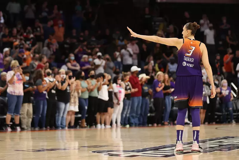 Image: diana taurasi waves to someone on a basketball court