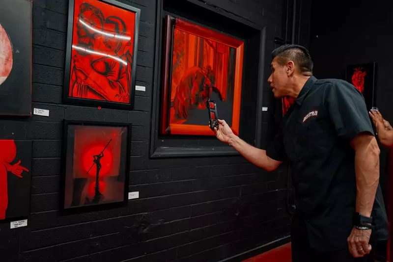Image: Artist Such Styles photographs a piece of art.