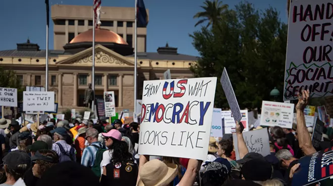 protesters at the arizona capitol. one sign says "show us what democracy looks like"
