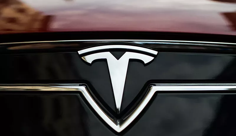 Image: a tesla logo on the front of a car