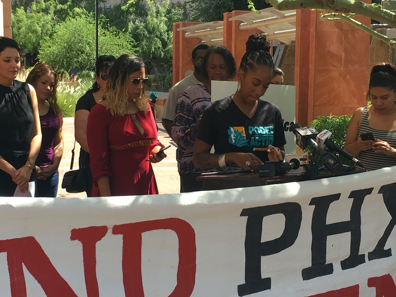 Erica Reynolds (in red) stands with supporters in a press conference announcing her legal action against the city of Phoenix.