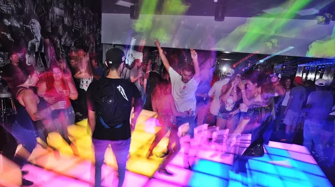 People on a lit-up dance floor.