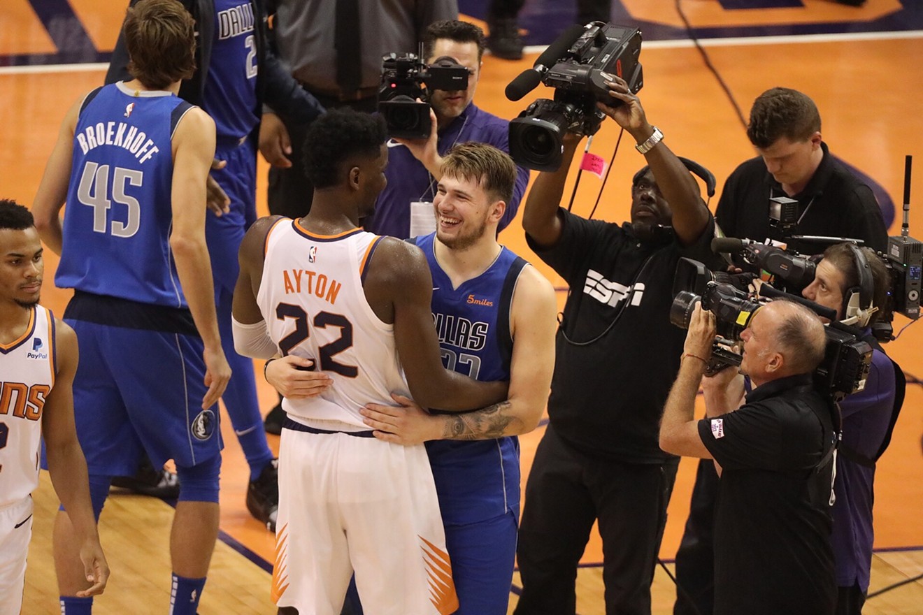 Heralded rookies Deandre Ayton (22) of the Suns and Luka Doncic  of the Dallas Mavericks are surrounded by media as they chat after Wednesday's game.