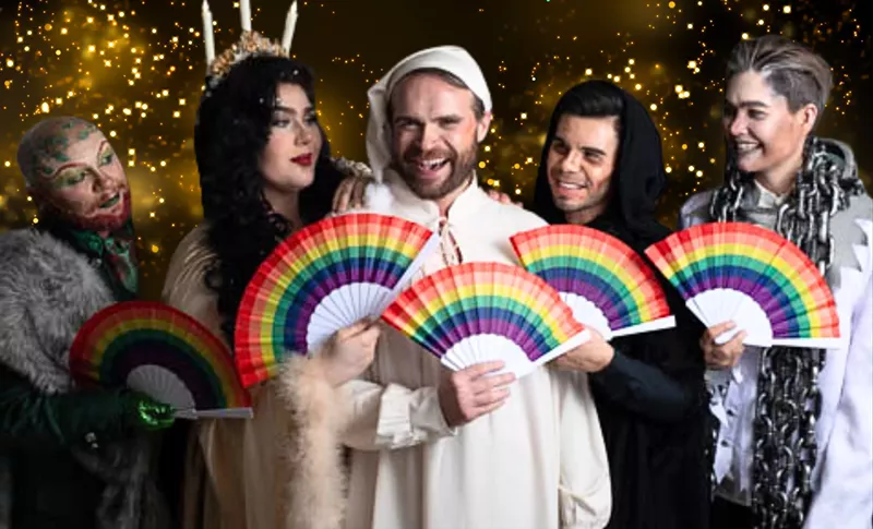 Image: A group of people in old-fashioned clothing holding rainbow-colored fans.