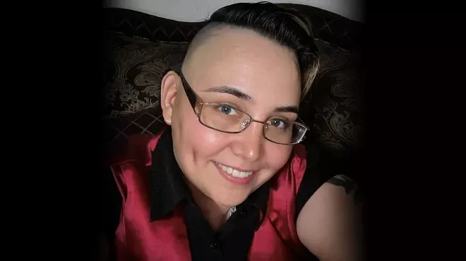 a woman with close-cropped hair and glasses in a selfie