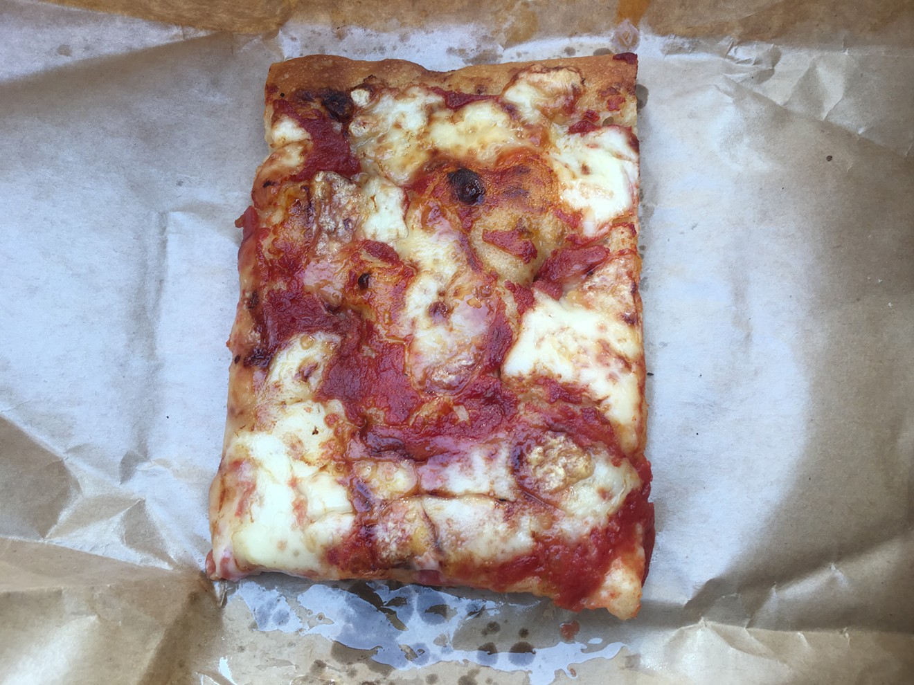 A cut of thick al taglio pizza from Pane Bianco