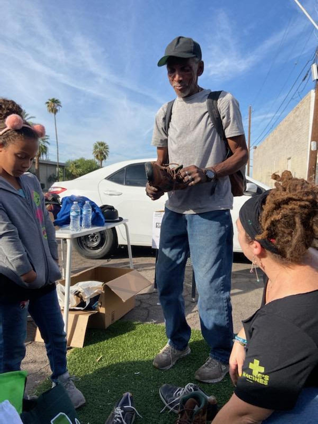 During one of the first Tom's Palms events, Sheena Williams and her daughter help a man pick out a pair of boots for the upcoming monsoon season in Phoenix.