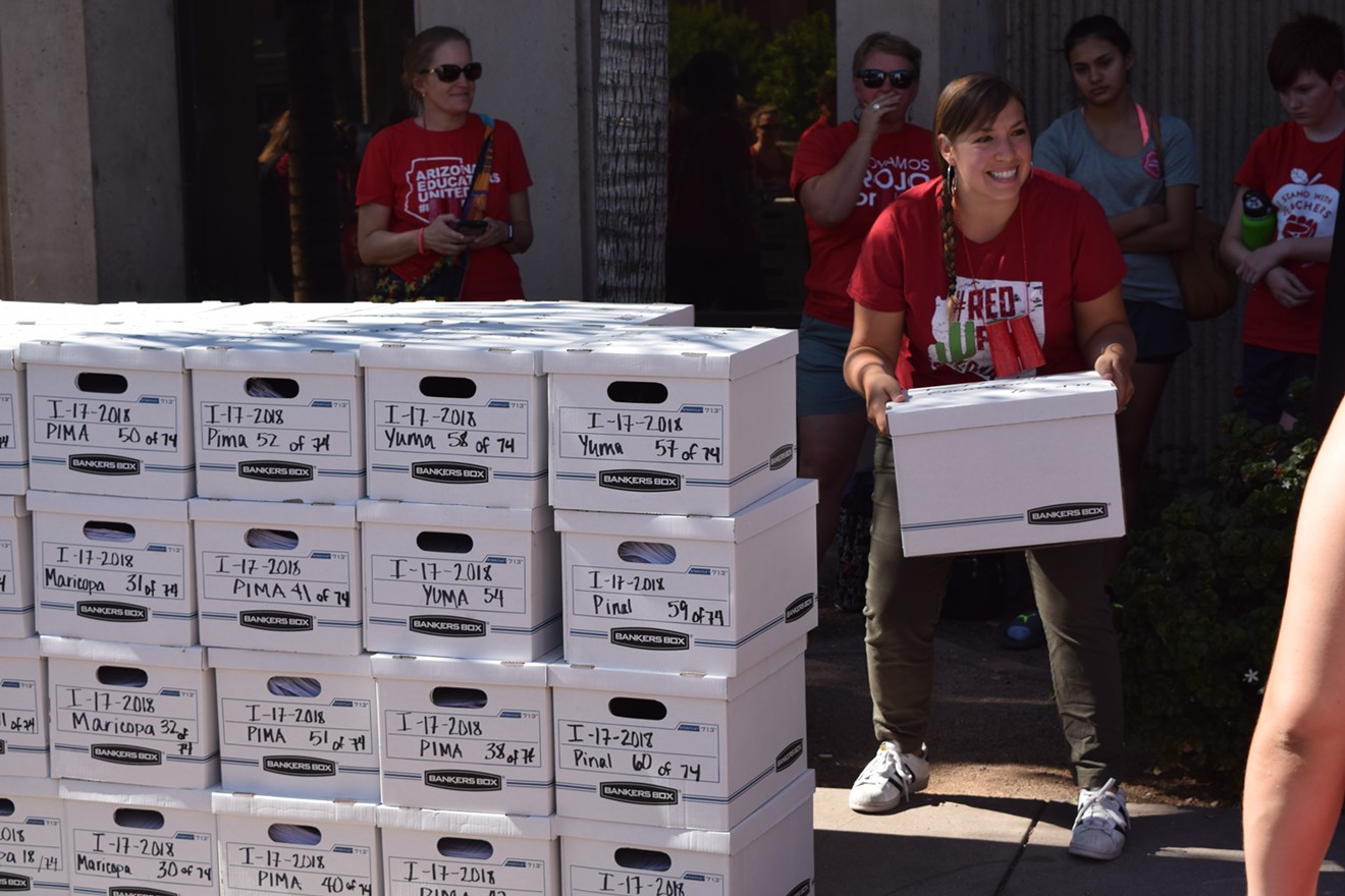 Rebecca Garelli, one of the #RedForEd leaders, poses with boxes of signatures for the "Invest in Education Act."
