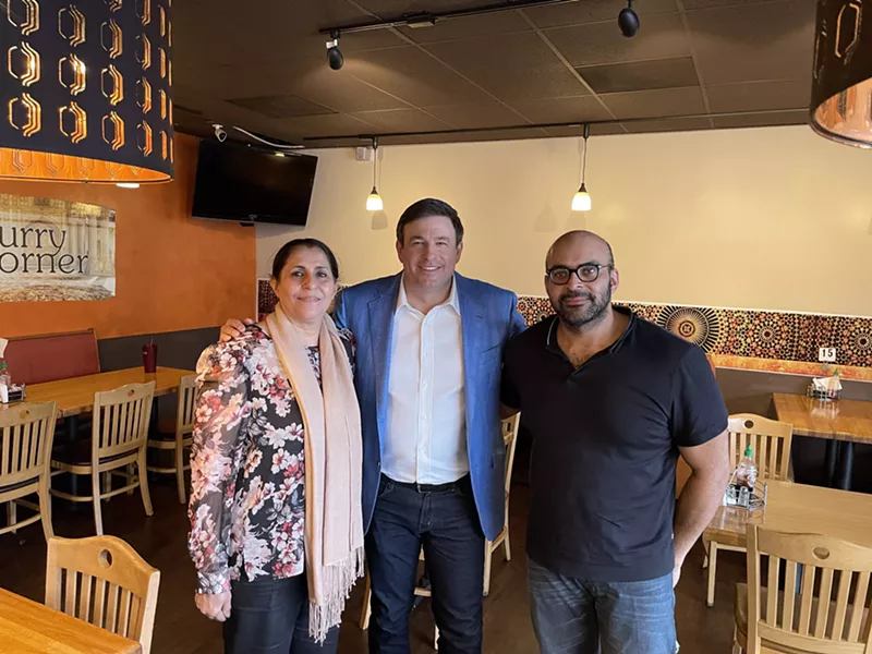 Image: Founder of Cane's CEO poses with Farah Khalid and her son, Omar, during the filming of the television show Restaurant Recovery.