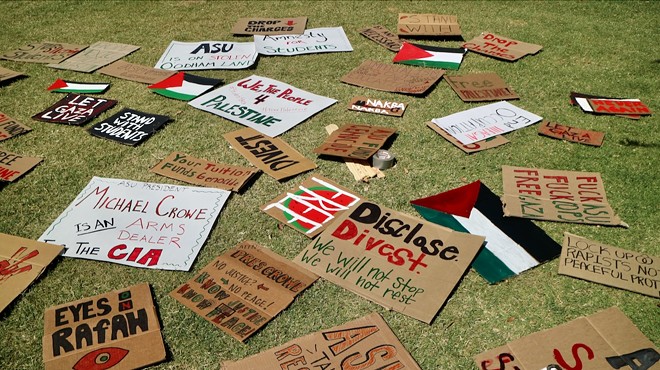 Cardboard signs lying on a green patch of grass.