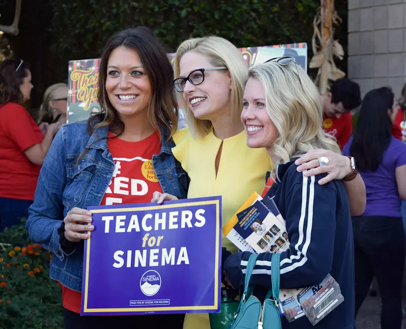 Image: Senate candidate Kyrsten Sinema hugs canvassers for a photo op on November 3 at the Arizona Education Association.