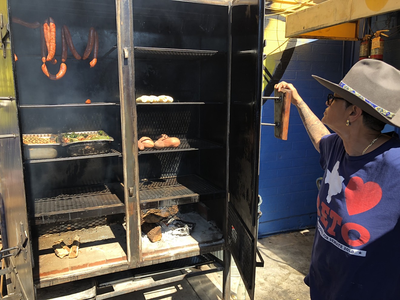 Esparza checking on meat and vegetables in her new upright smoker.
