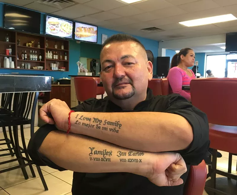 Image: Carlos Cárdenas, chef and owner of Mariscos El Dorado at 5630 South Central Avenue, showing the tattoos on his arms honoring his family.