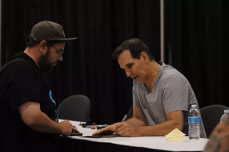 Image: Famed comics creator Todd McFarlane signs an autograph in the Hall of Heroes.