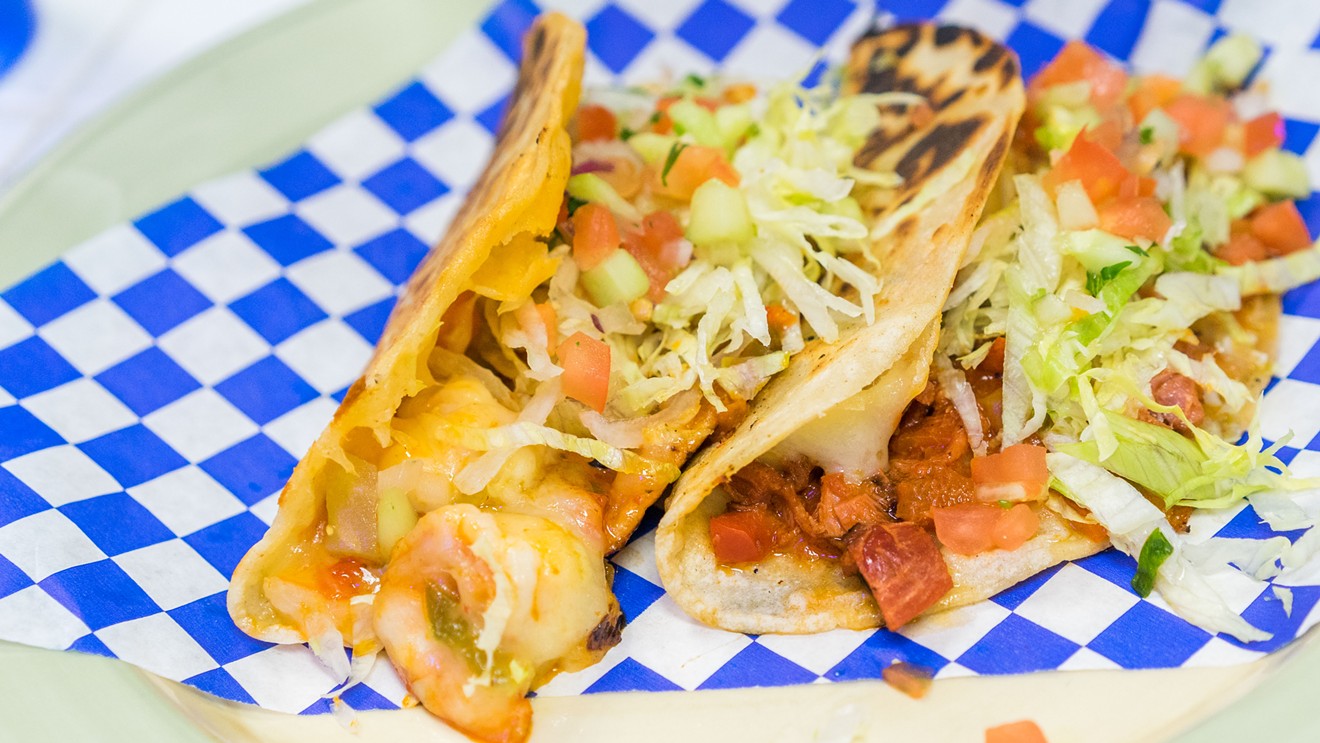 Mariscos Ensenada may be better known for ceviche and micheladas, but they also serve a warm and saucy shrimp taco studded with bacon and cheese, pictured on the left. On the right is a marlin taco served in a similar fashion.