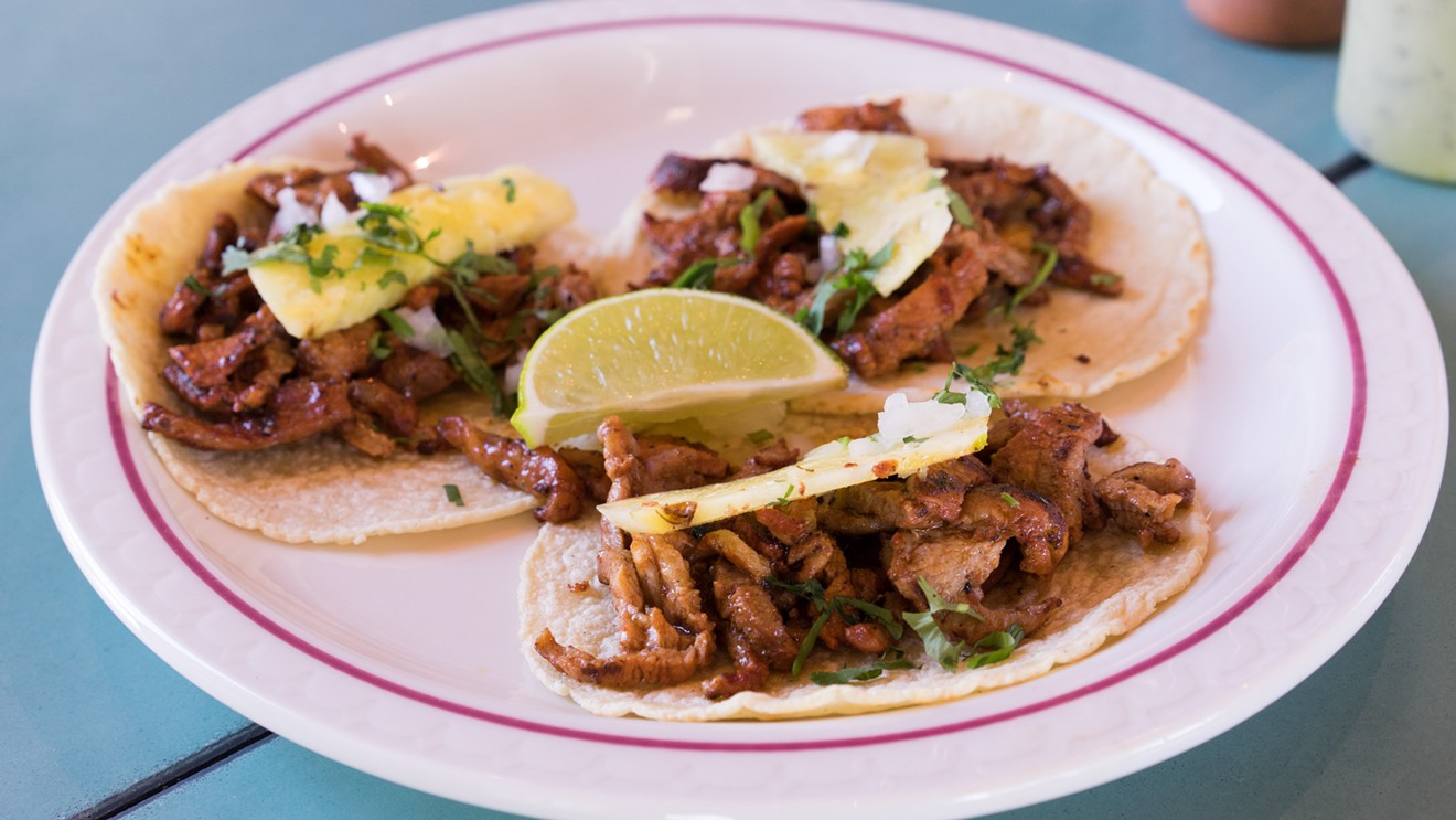 Al pastor, grilled over a wood fire and then finished in a ripping hot wok, comes together atop tacos, topped with onion, cilantro, and a thin sliver of pineapple.