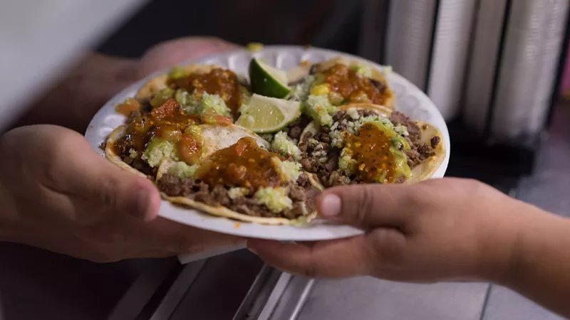 Image: A plate of steak tacos, topped with Los Yaquis' signature bitter, spicy salsa and avocado sauce, goes out to a patient customer.