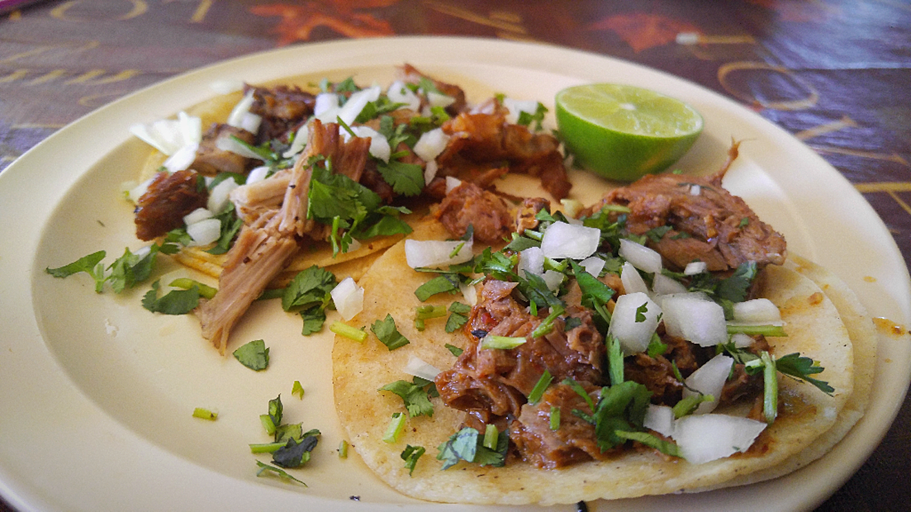 A succulent birria taco (right) and a carnitas taco (left), a popular lunch combo at this west side taqueria.