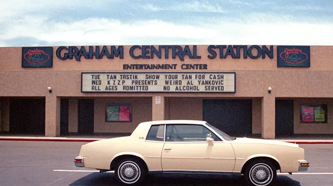 Exterior photo of a nightclub with a car parked in front.