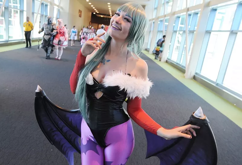 Image: A cosplayer at Phoenix Comic Fest dressed as Morrigan Aensland from Darkstalkers.