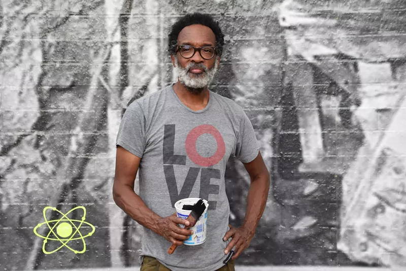 Image: Chip Thomas pauses from putting finishing touches on his new mural at Eye Lounge.
