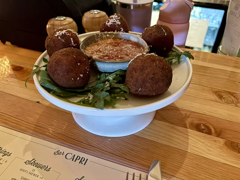 Image: A cake stand filled with arancini is the perfect way to start your meal at Bar Capri.