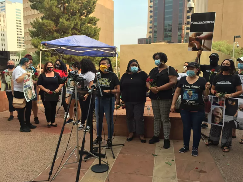 Image: Viri Hernandez, executive director of Poder in Action, stands with families of Phoenix Police shooting victims on August 26.