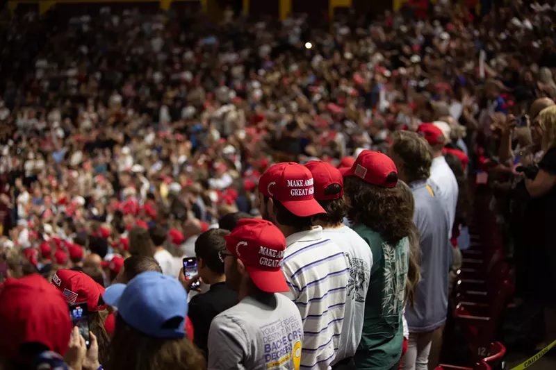 Image: a crowd of people in red MAGA hats