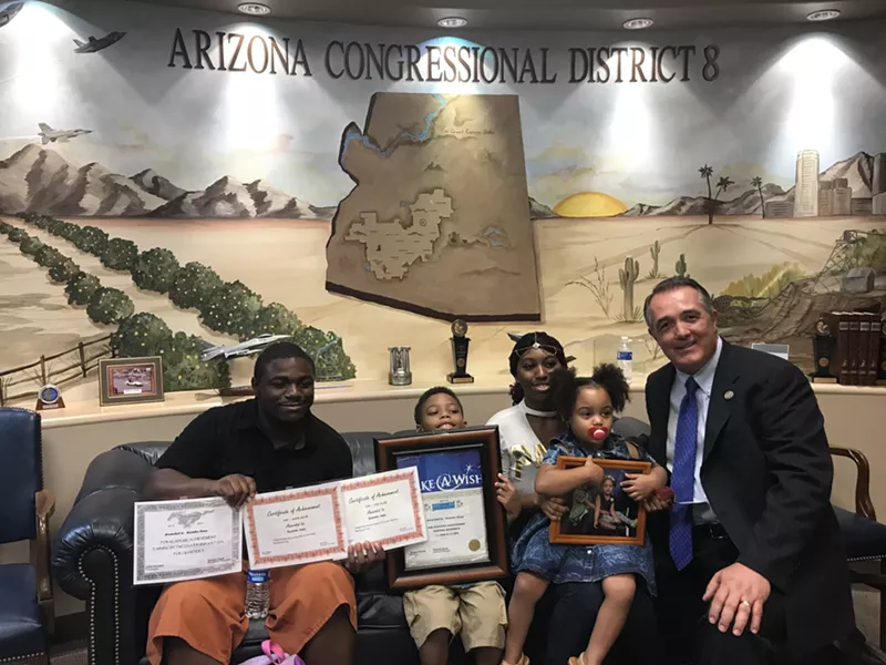 Image: Brianna Huey and her boyfriend, Malcom Williams, and Huey's two children, Eastahn and Melianna, pose with Representative Trent Franks at his congressional office. The Huey family relies on health care coverage from the government and urged Franks to not support the Senate bill.